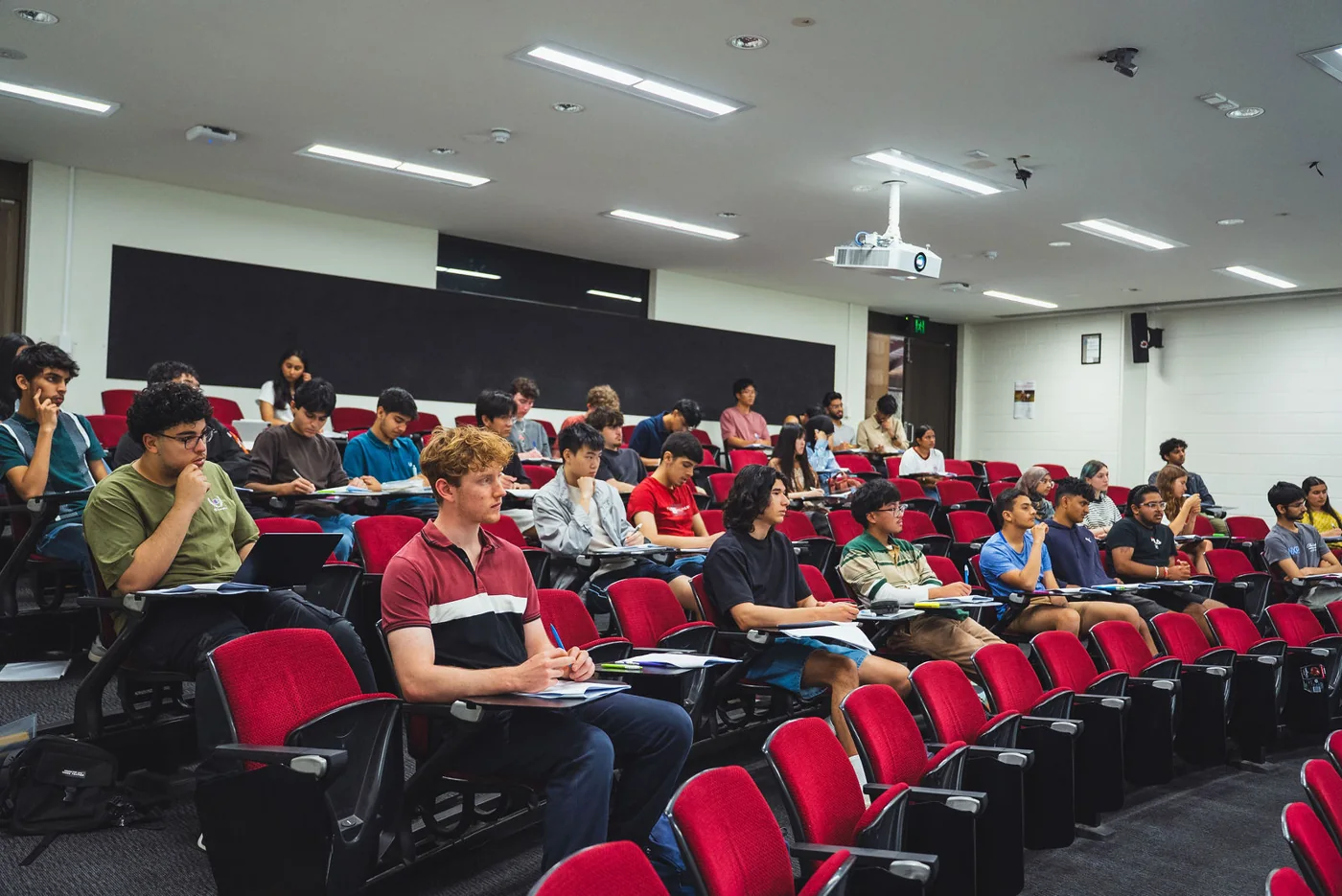 Students writing notes in a lecture theatre at an Everest interview course